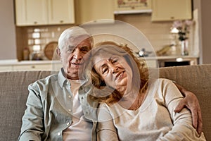 Senior caucasian couple sitting on sofa at home