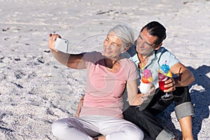 Senior Caucasian couple taking a selfie at the beach.