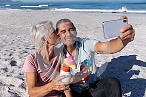 Senior Caucasian couple taking a selfie at the beach.