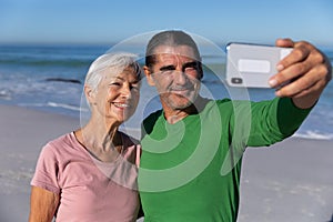 Senior Caucasian couple taking a selfie at the beach.