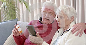 Senior caucasian couple using smartphone for online doctor consultation at home, slow motion