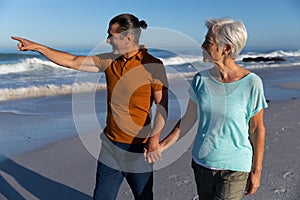 Senior Caucasian couple walking at the beach.