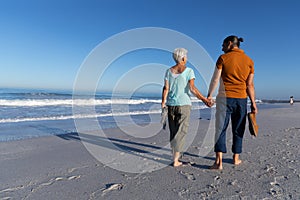 Senior Caucasian couple walking at the beach.