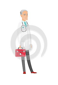 Senior caucasian doctor holding first aid box.