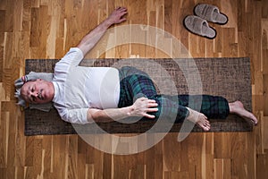 Senior caucasian man doing yoga Spine twisting pose