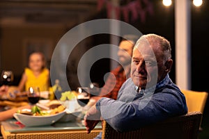 Senior Caucasian man sitting at the table and looking at camera