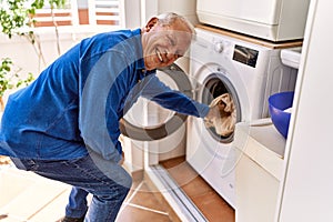 Senior caucasian man smiling happy doing laundry at the terrace