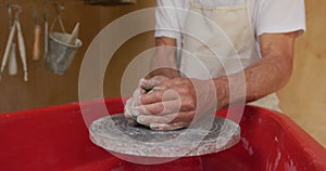 Senior caucasian man wearing apron making pottery in his workshop