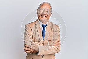 Senior caucasian man wearing business suit happy face smiling with crossed arms looking at the camera