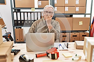 Senior caucasian man working at small business ecommerce with laptop bored yawning tired covering mouth with hand