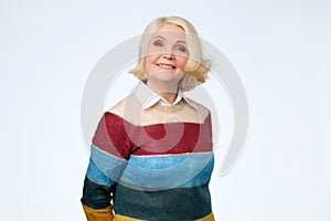 Senior caucasian woman with blonde hair in colored sweater smiling