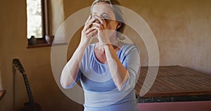 Senior caucasian woman drinking mug of coffee in rustic living room