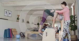 Senior caucasian woman exercising in pilates class with female coach, unaltered, in slow motion