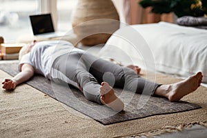 Senior caucasian woman lying on yoga mat after workout