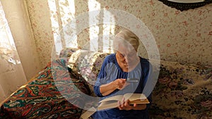 Senior caucasian woman reading a book at home