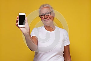 Senior caucasian woman showing blank smartphone screen