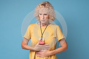 Senior caucasian woman suffering from stomach pain and indigestion