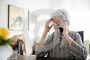 Senior Caucasian woman talking on a phone in her home