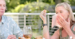 Senior Caucasian women enjoy a meal outdoors