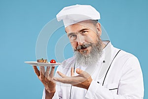 Senior Chef Presenting Dish on Blue