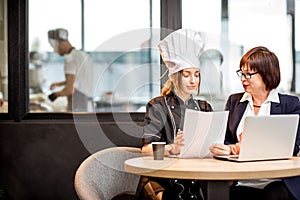 Senior chef and young cook at the restaurant