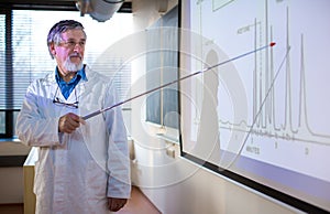 Senior chemistry professor giving a lecture in front of classroom full of students