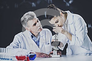 Senior chemistry professor and his assistant working in laboratory