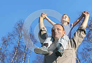Senior with child on shoulders in front of birch photo