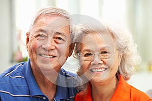 Senior Chinese Couple Relaxing On Sofa At Home