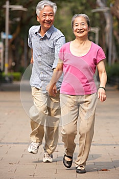 Senior Chinese Couple Walking In Park