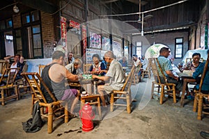 Senior chinese people playing mahjong in an ancient tearoom