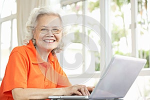 Senior Chinese Woman Using Laptop At Home