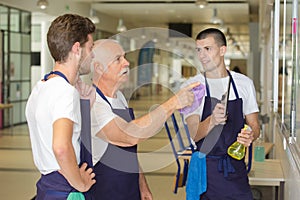 Senior cleaner explaining job to younger coleagues photo