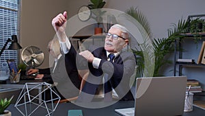 Senior confident businessman grandfather company director showing biceps feeling power strength