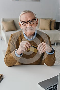 Senior confident man holding credit card