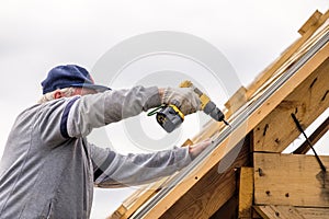 Stavitel muž šroubovák šroubování zastřešení list na střecha 