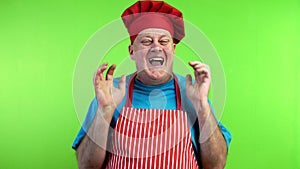 Senior cook in apron hysterically laughing over funny joke.