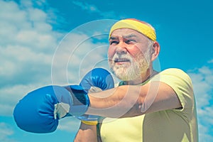 Senior cool man fighting. Best cardio workout. Senior man wearing boxing gloves. Portrait of a determined senior boxer