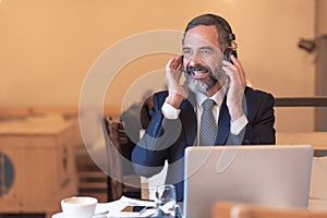 Senior corporate businessman enjoying some music