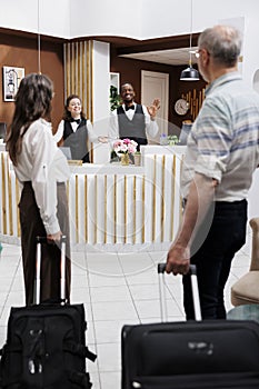 Senior couple approach hotel front desk