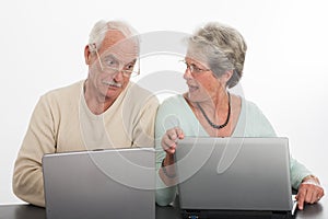 Senior couple arguing with laptops