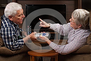 Senior couple arguing over TV remote control