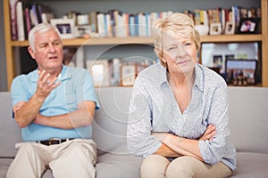 Senior couple arguing while sitting on sofa