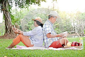 Senior Couple, Asian Husband and Wife Sit and picnic and relax in the park.