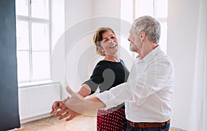 Senior couple attending dancing class in community center.