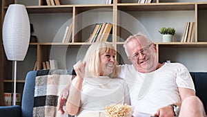 Senior couple of basketball fans watching sports TV games sitting together on couch, emotional sport