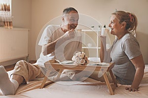 Senior couple in bed. Senior people drinking coffee in bed.