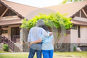 Senior couple from behind looking at front of house