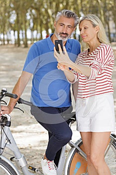 Senior couple with bicycles taking selfie