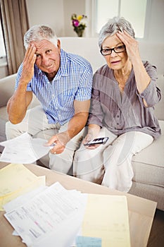 Senior couple with bills looking worried